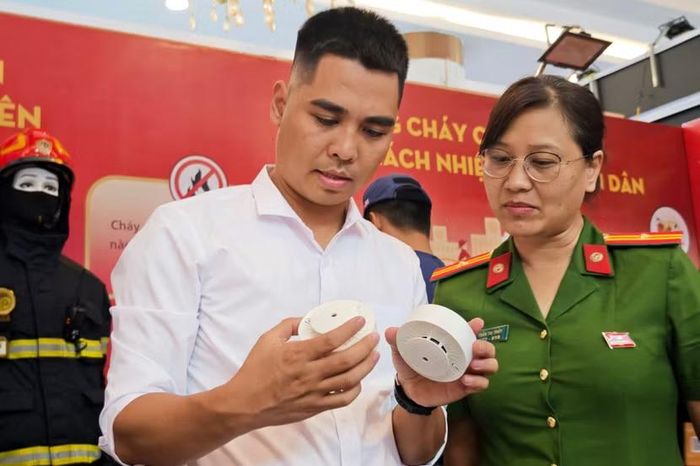 Thiết kế nguyên khối gọn gàng, trọng lượng nhẹ, người dân có thể dùng băng keo chuyên dụng dán thẳng đầu báo lên trần nhà trọ. Tại gian hàng, người dân trực tiếp kiểm tra khe tản khói và độ hoàn thiện phần cứng của thiết bị đầu cuối.