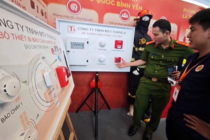 Sản phẩm công nghiệp an ninh của Công an Hà Nội cũng thu hút sự quan tâm của các đơn vị khác trong lực lượng. Cán bộ PCCC phân tích sự khác biệt giữa tủ trung tâm báo cháy có dây truyền thống (bên trái) và hệ thống không dây mới. Thiết bị mới triệt tiêu hoàn toàn rủi ro chập cháy do chuột cắn đứt cáp tín hiệu đi ngầm trong tường.