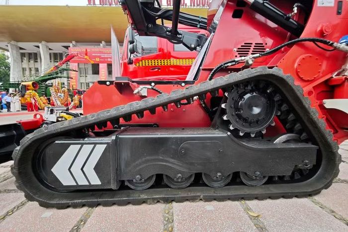 Để gánh được khối lượng đồ sộ và càn lướt qua gạch ngói ngổn ngang, robot di chuyển bằng hệ thống bánh xích bọc cao su chịu nhiệt độ cao, tích hợp ngàm chống trượt. Trọng tâm thấp giúp máy leo dốc 30 độ mà không bị lật.