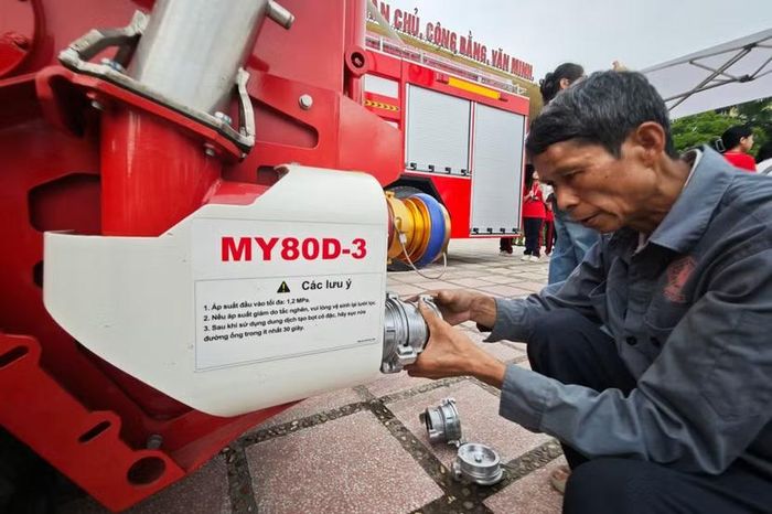 Người dân Thủ đô và giới chuyên môn liên tục dừng chân, soi kỹ từng chi tiết cơ khí. Một người đàn ông lớn tuổi tỉ mẩn kiểm tra cụm ngàm nối đuôi xe - nơi phải gánh chịu áp suất nước đầu vào lên tới 1.2 MPa từ xe bồn dội tới.