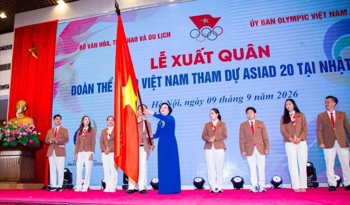 Bí thư Trung ương Đảng, Phó Thủ tướng Chính phủ Phạm Thị Thanh Trà phất cao và trao lại lá cờ Tổ quốc cho Trưởng đoàn Thể thao Việt Nam Nguyễn Hồng Minh (Ảnh: Quý Lượng)