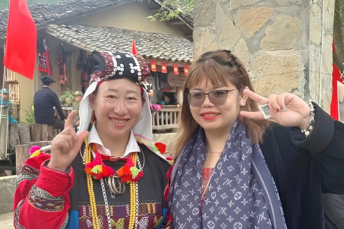  Hà My (áo đen) chụp ảnh cùng người dân tại thôn Lô Lô Chải. 