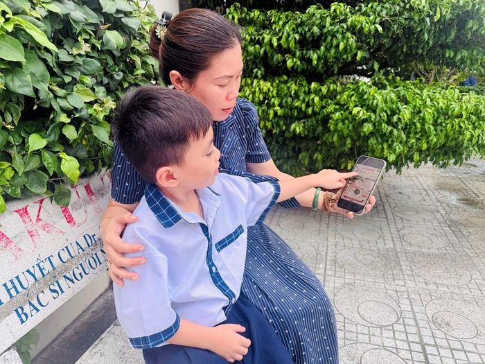 Chị Hoàng Thị Ngọc Thơ, cán bộ Hội Liên hiệp Phụ nữ tỉnh An Giang đang hướng dẫn cho con vào trang tìm hiểu thông tin về sách