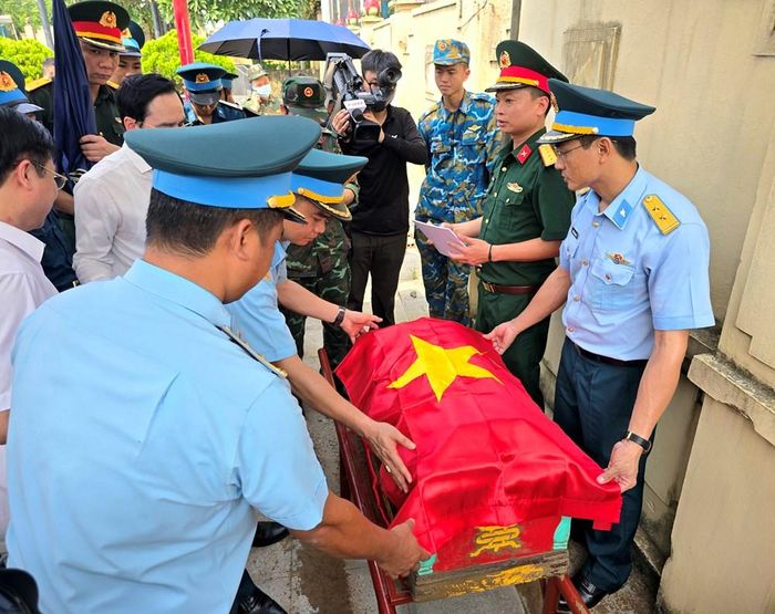 Tiểu hài cốt được phủ Quốc kỳ và đưa vào khu vực lấy mẫu ADN