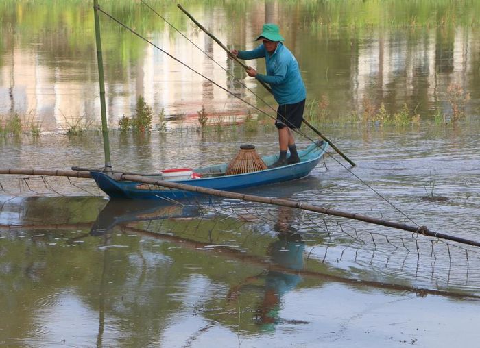 Người dân giăng lưới, đặt dớn để bắt cá, tôm và các sản vật tự nhiên mùa lũ. Ảnh: Duy Khương – TTXVN