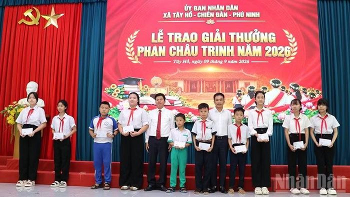 Đồng chí Phan Thái Sơn, quyền Trưởng Cơ quan đại diện Báo Nhân Dân tại miền trung-Tây Nguyên và đồng chí Võ Công Chánh, Trưởng Ban Nội chính Thành ủy Đà Nẵng trao quà cho các em học sinh có hoàn cảnh khăn trên địa bàn xã Tây Hồ. (Ảnh: ANH QUÂN)