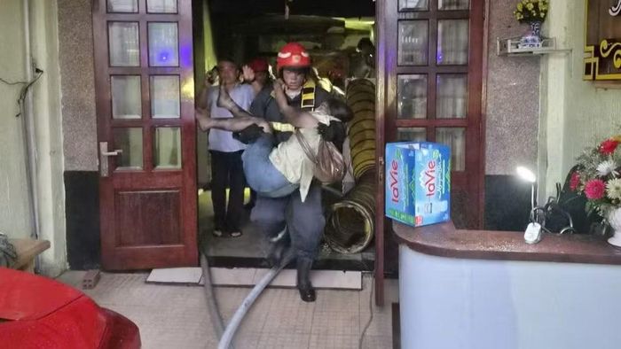 Lực lượng phòng cháy, chữa cháy đưa một nạn nhân vụ cháy ra ngoài. (Ảnh: Cộng tác viên)