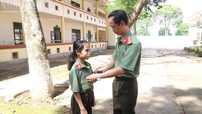 Những ngày đầu vào trường, các em được các thầy cô hướng dẫn tỉ mỉ cách mặc trang phục. (Ảnh: Công Lý)