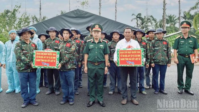 Thượng tướng Lê Quang Minh tặng quà động viên lực lượng thực hiện nhiệm vụ lấy mẫu hài cốt liệt sĩ chưa xác định được thông tin tại Nghĩa trang liệt sĩ Tiền Giang, tỉnh Đồng Tháp. (Ảnh: CHÍ PHÚC)