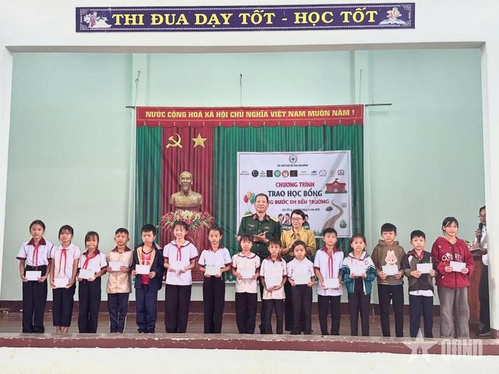  Chỉ huy Đoàn Kinh tế - Quốc phòng 720 và đại diện ban giám hiệu nhà trường chụp hình lưu niệm với các học sinh được tặng quà.  