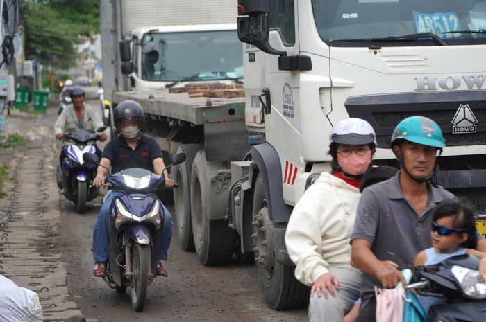 Xe ô tô tải chen vào làn xe máy đoạn gần nút giao Cổng 11, quốc lộ 51 gây mất an toàn giao thông. Ảnh: PHÚ NGÂN