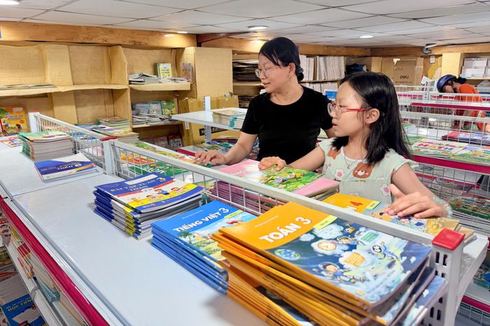 Phụ huynh tìm mua SGK cho con tại Nhà sách Thái Bình (phường Tân Hưng, TPHCM) vào tối 8-9. Ảnh: HOÀNG HÙNG