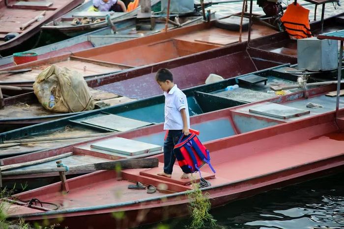 Thuyền chở học sinh qua sông cập bến.