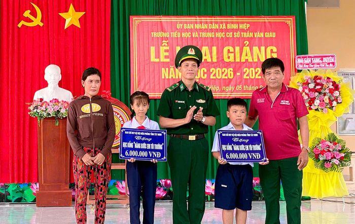 Cô ruột cùng em Phan Thị Ngọc Châu (em bên trái) nhận học bổng “Nâng bước em tới trường” trong ngày Lễ khai giảng vừa qua (ảnh: Đinh Quân)
