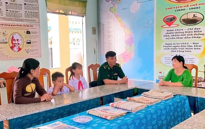 Thiếu tá Nguyễn Hồng Thân, Chính trị viên phó Đồn Biên phòng Thạnh Trị trao đổi, nắm bắt tình hình kết quả học tập, rèn luyện của em Ngọc Châu với giáo viên chủ nhiệm (ảnh: Đinh Quân)