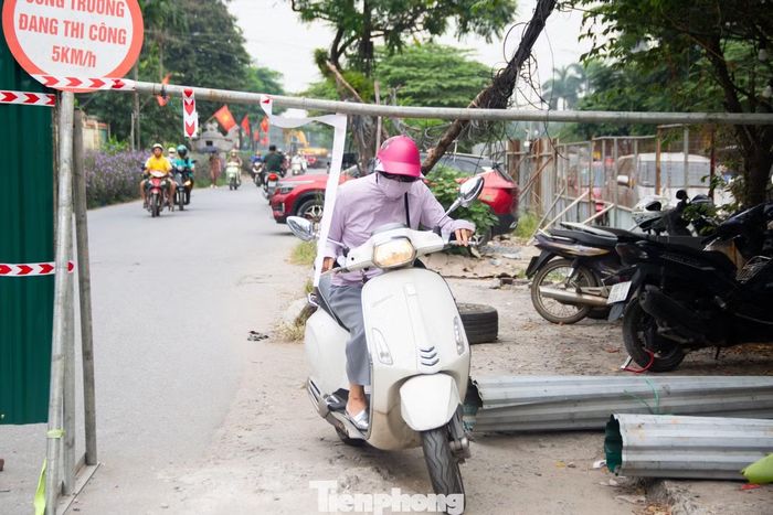 Nhiều người điều khiển xe máy chật vật đi lên vỉa hè, cố gắng lách qua khu vực vừa rào chắn nhằm tiếp tục di chuyển theo hướng đi quen thuộc.