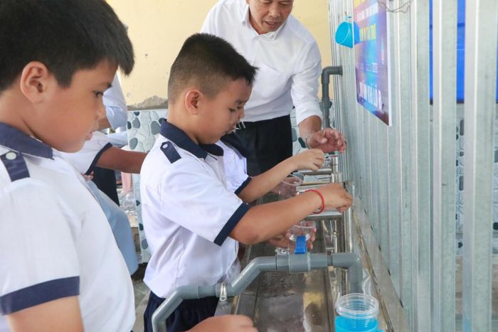 Các em học sinh tại An Giang sử dụng nước sạch từ hệ thống do Dự án Phát triển mỏ khí Lô B tài trợ.