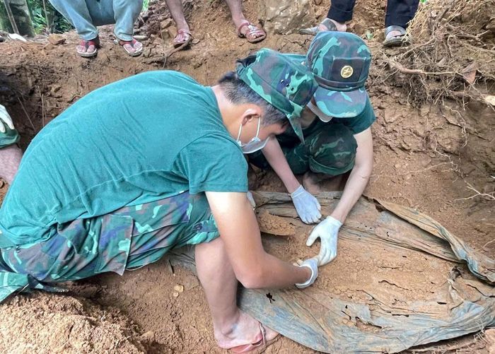 Lực lượng chức năng khai quật hài cốt liệt sĩ tại khu vực đồi thuộc thôn 1, xã Trà Giáp. Ảnh: Quang Cường