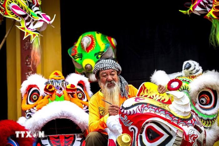 Từ khung tre mộc mạc, qua bàn tay nghệ nhân, đầu lân trở thành tác phẩm nghệ thuật. (Ảnh: Giang Phương/TTXVN)