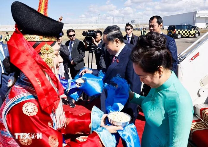 Hai thiếu nữ Mông Cổ tặng khăn Khadag và mời Chủ tịch Quốc hội Trần Thanh Mẫn và Phu nhân dùng bánh Aaruul theo nghi thức đón khách truyền thống của Mông Cổ. (Ảnh: Doãn Tấn/TTXVN)