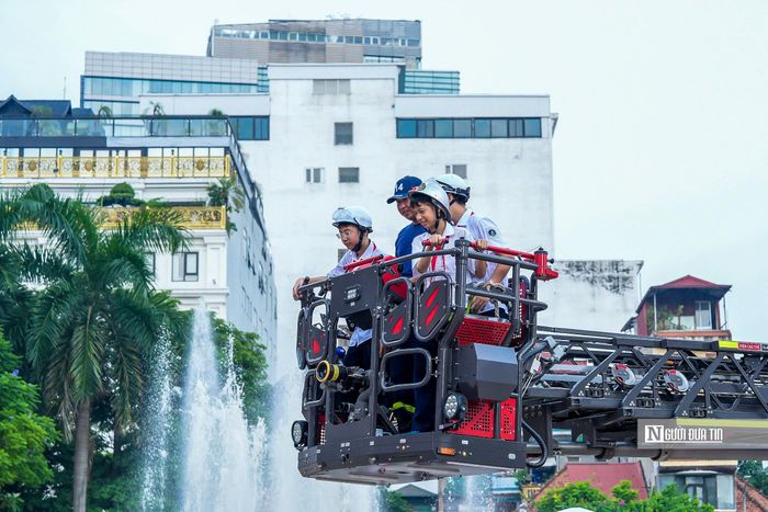 Các em học sinh hào hứng trải nghiệm mô hình thang cứu hộ của lực lượng phòng cháy chữa cháy và cứu nạn cứu hộ.