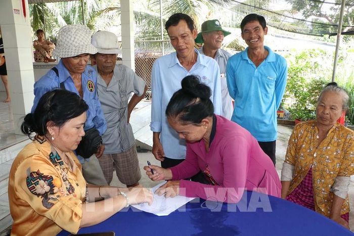 Người dân ấp Phương Thạnh, xã Phương Bình, thành phố Cần Thơ ký biên bản ủng hộ tại buổi họp dân thực hiện tuyến đường nông thôn Quang Phong, dài hơn 2km. Ảnh: Duy Khương – TTXVN