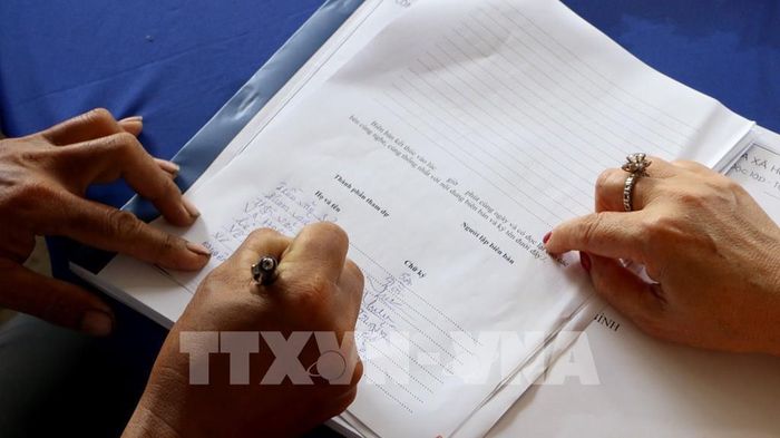 Người dân ấp Phương Thạnh, xã Phương Bình, thành phố Cần Thơ ký biên bản ủng hộ tại buổi họp dân thực hiện tuyến đường nông thôn Quang Phong, dài hơn 2km. Ảnh: Duy Khương – TTXVN