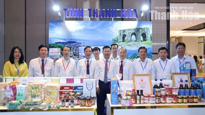 Phó Chủ tịch UBND tỉnh Đầu Thanh Tùng và các đại biểu tỉnh Thanh Hóa chụp ảnh lưu niệm tại không gian trưng bày sản phẩm tiêu biểu tỉnh Thanh Hóa.