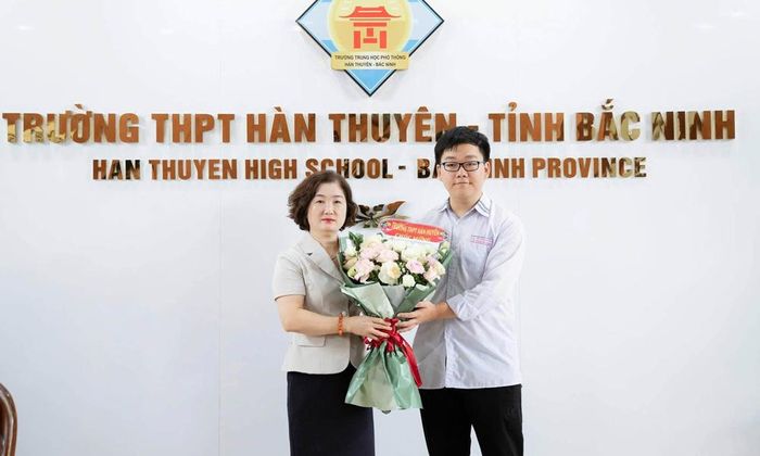  Nhà giáo Đặng Thị Bích Vân - Hiệu trưởng Trường Trung học phổ thông Hàn Thuyên tặng hoa chúc mừng em Lê Minh Đức - Thủ khoa đầu vào Trường Đại học Y Hà Nội. 