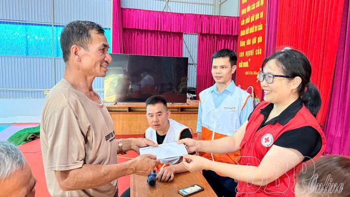 Người dân xã Nậm Nèn được tuyên truyền phòng ngừa, ứng phó thiên tai và nhận tiền tại điểm hỗ trợ.