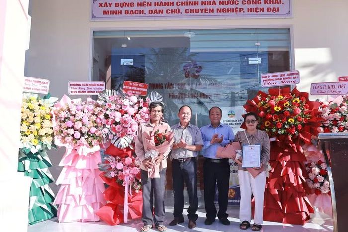  Lãnh đạo Đảng ủy, UBND phường Hoài Nhơn Tây trao giấy khai sinh, tặng hoa cho các công dân đầu tiên đến làm thủ tục tại Trung tâm Phục vụ hành chính công trong ngày khánh thành. Ảnh: Hoài Huy 