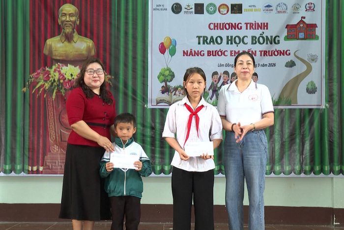 Bà Nguyễn Thị Chín, Chủ tịch Hội Chữ thập đỏ tỉnh (áo đỏ) và bà Nguyễn Thị Hà, Phó Chủ tịch Hội Chữ thập đỏ tỉnh, Trưởng Ban điều hành "Nâng bước em đến trường" (áo trắng) trao tặng 2 suất học bổng cho các em có hoàn cảnh đặc biệt khó khăn