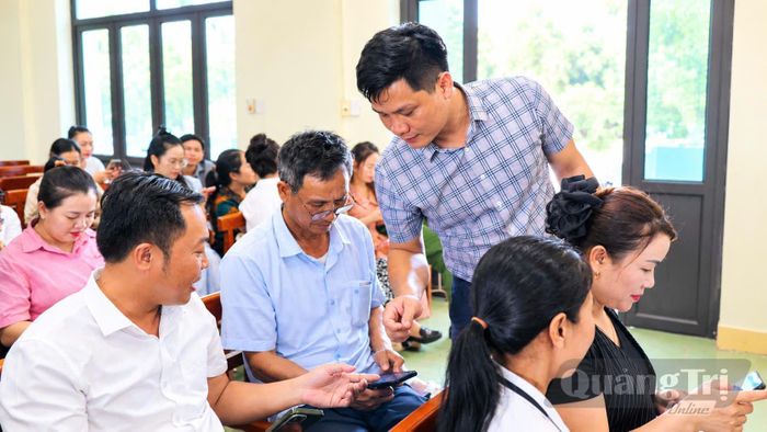 Cán bộ xã hướng dẫn người dân cài đặt, sử dụng công nghệ số - Ảnh: P.N