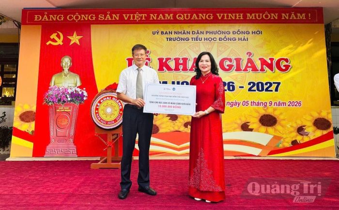 Ông Lương Ngọc Bính, Chủ tịch Liên hiệp các tổ chức hữu nghị tỉnh trao tặng học bổng cho học sinh - Ảnh: CTV