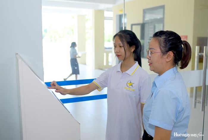 Cán bộ Trung tâm Phục vụ hành chính công phường An Cựu hướng dẫn công dân sử dụng công nghệ số vào giải quyết thủ tục hành chính.