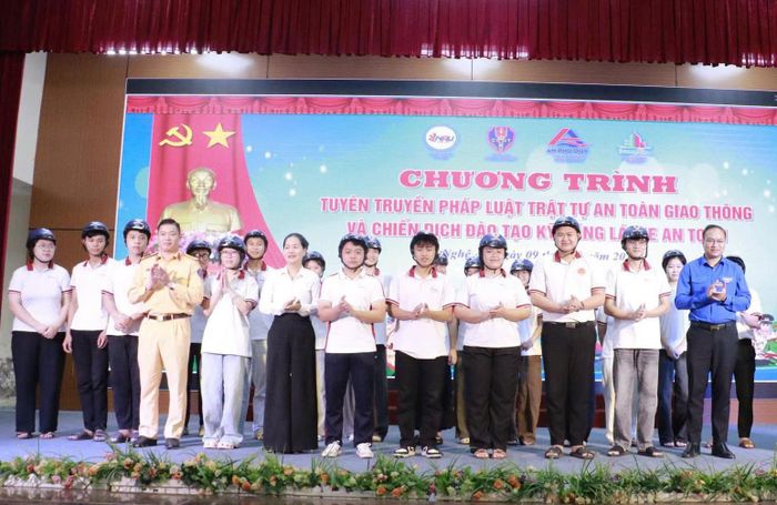 Ban tổ chức trao mũ bảo hiểm đạt chuẩn cho sinh viên. (Ảnh: CSGTNA).