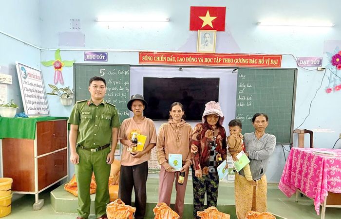 "Thầy giáo" mặc sắc phục Công an tặng sách vở, nước tương, dầu ăn, gạo cho các học viên lớp bình dân học vụ.