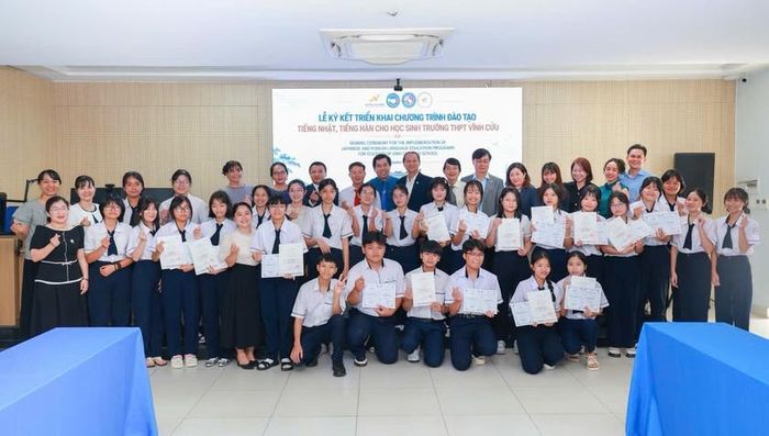 Lãnh đạo các đơn vị và các em học sinh tại lễ ký kết.