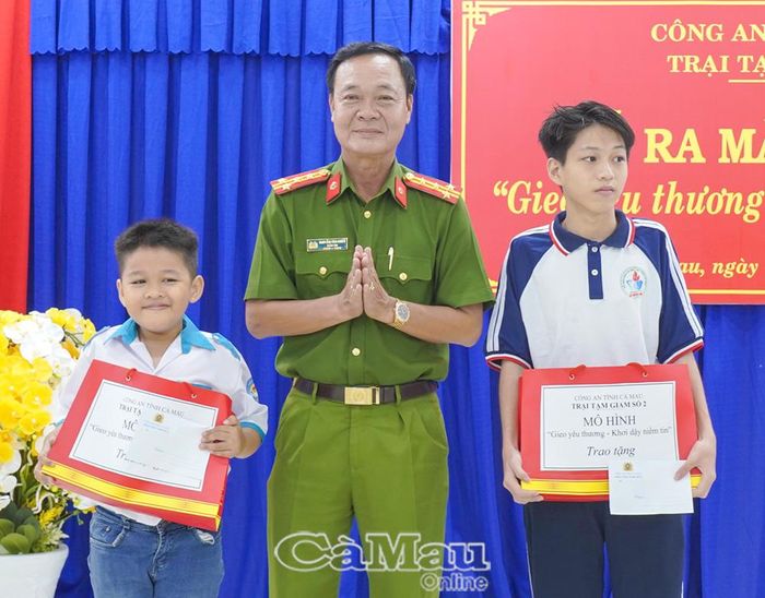 Đại tá Nguyễn Văn Chiến, Giám thị Trại tạm giam số 2, Trưởng Ban Chỉ đạo mô hình, trao quà cho con cán bộ, chiến sĩ có thành tích cao trong học tập.