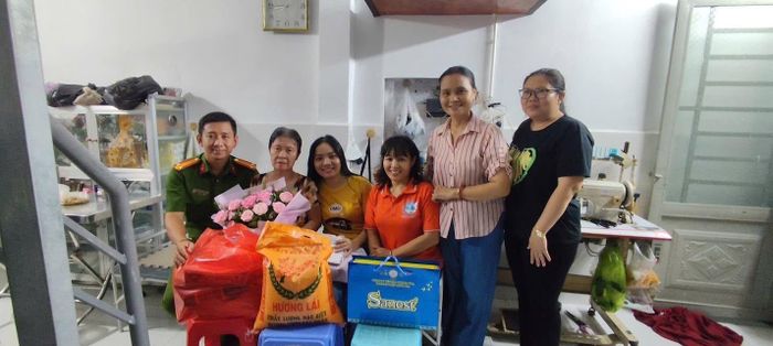 Đại diện cơ quan chức năng và chị Vân trao quà cho bà Mùi. Ảnh: CA. ↵