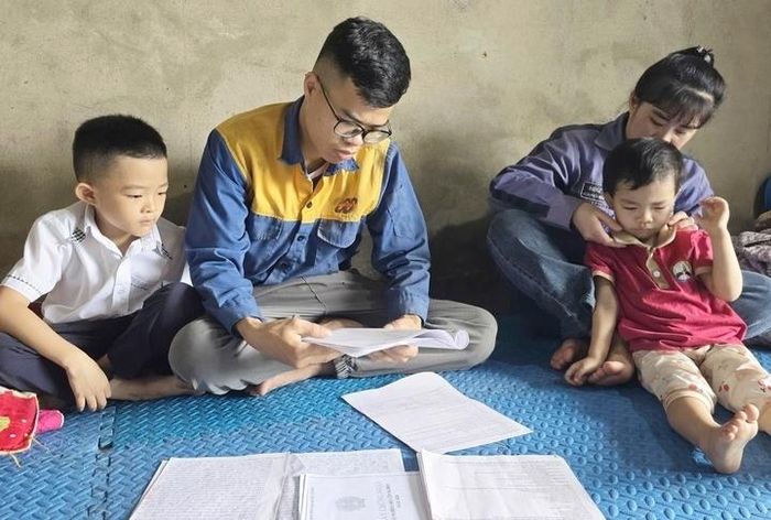 Anh Quý cùng các con xem lại lịch truyền máu trong tháng. (Ảnh: Như Loan)
