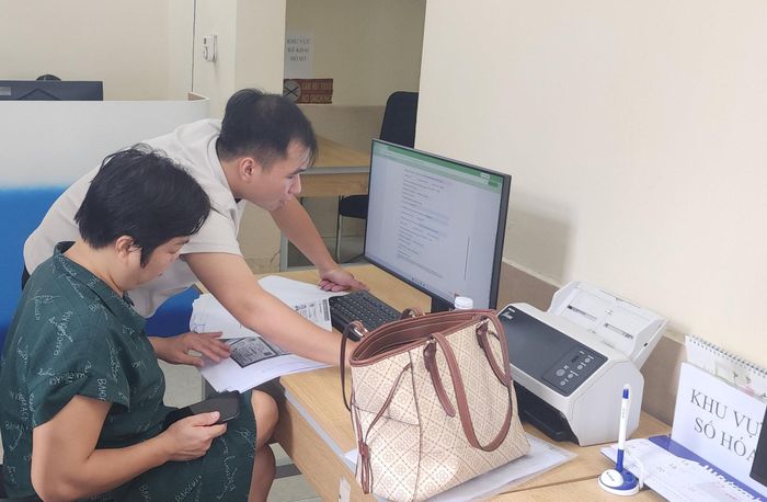 Cán bộ trực tiếp hỗ trợ người dân thao tác trên Cổng dịch vụ công, nhất là với những người chưa thành thạo công nghệ. Ảnh: Việt Thắng