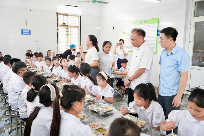 Bí thư Đảng ủy, Chủ tịch HĐND xã Đan Phượng Nguyễn Gia Hiển kiểm tra tổ chức ăn trưa và các suất ăn của học sinh. Ảnh: Ngân Nguyễn