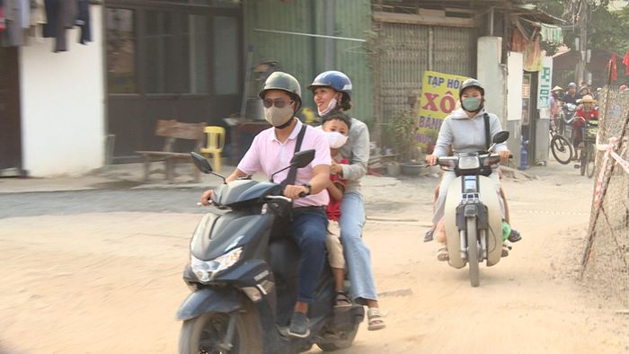 Vợ chồng anh Nguyễn Duy Tuyến trên đường đón con đi học về. Ảnh: Thái Trọng.