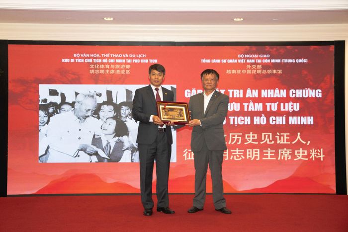 Ông Nguyễn Văn Dương, Phó Giám đốc Khu Di tích Chủ tịch Hồ Chí Minh tại Phủ Chủ tịch trao tặng Phù điêu Nhà sàn Bác Hồ cho ông Phạm Gia Đức, Chủ tịch Hội người Việt tại Vân Nam. Ảnh: BTC