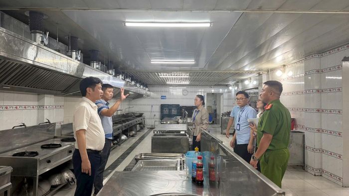 Chủ tịch UBND xã Trung Giã Nguyễn Bá Hoàng (ngoài cùng bên trái) cùng đoàn công tác làm việc với đơn vị cung cấp suất ăn bán trú trên địa bàn. Ảnh: Hương Ly