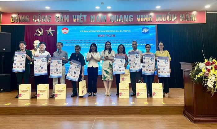 Ban Tổ chức trao tặng bảng tin số và tờ rơi Inforgraphic tuyên truyền, hướng dẫn thực hiện mô hình cho đại diện 25 Ban Công tác Mặt trận Tổ dân phố. Ảnh: TA