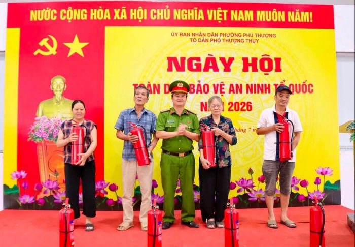 Trung tá Nguyễn Văn Thiện, Phó Trưởng Công an phường Phú Thượng trao tặng bình chữa cháy cho các hộ gia đình trên địa bàn Tổ dân phố Thượng Thụy. Ảnh: PT