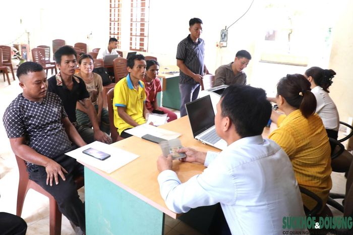 Cán bộ Trung tâm Phục vụ hành chính công xã Nhôn Mai trực tiếp hướng dẫn người dân làm thủ tục ngay tại bản. Ảnh: Song Hoàng.
