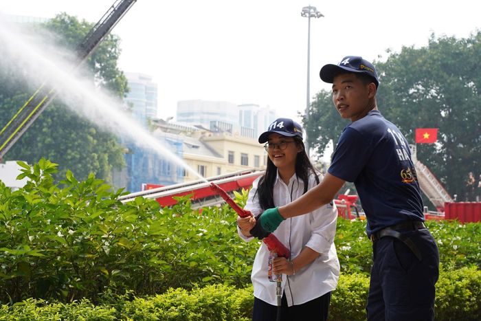 Trải nghiệm cầm vòi phun nước chữa cháy thu hút sự chú ý của nhiều học sinh. (Ảnh C.T.)